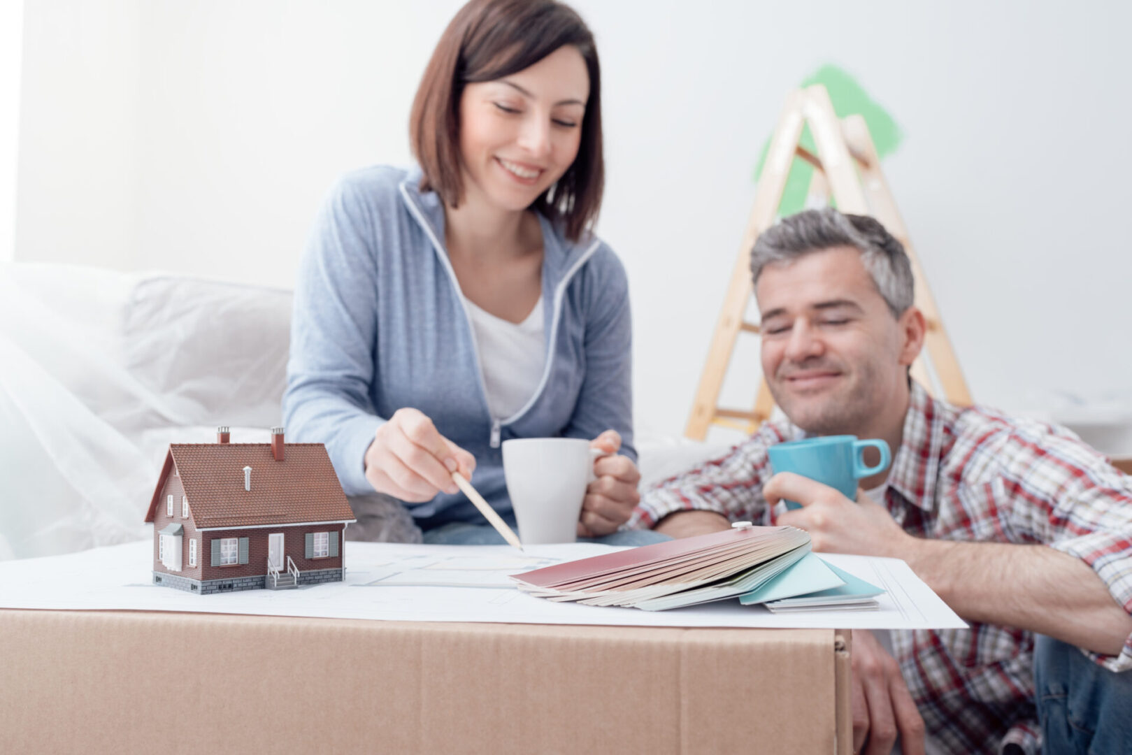 Happy couple designing their new house, they are checking the house project together and doing home renovations