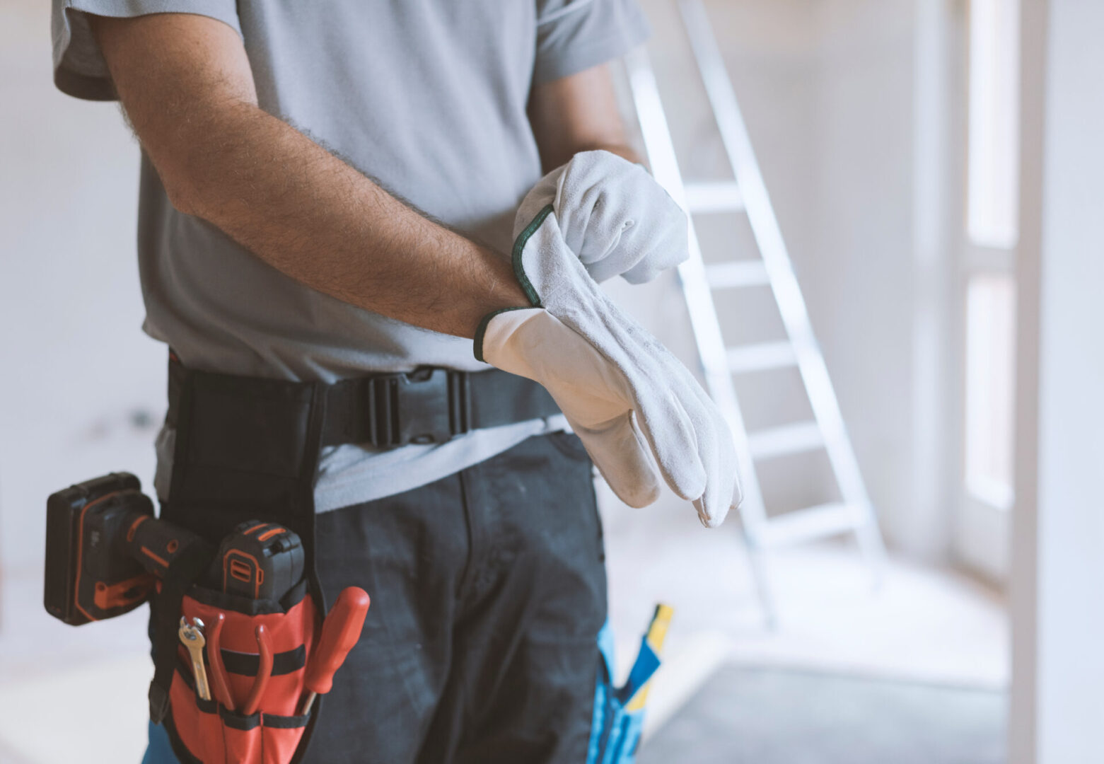 Professional repairman wearing protective gloves: home renovationa and safety concept